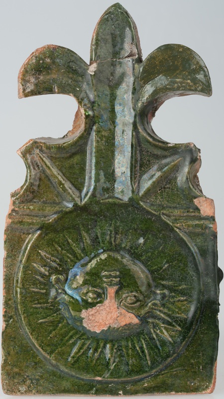 Kafel z wyobrażeniem słońca z ludzką twarzą i częścią w formie lilii 