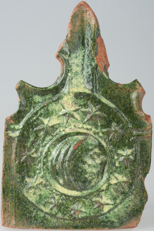 Kafel z sierpem księżyca z ludzką twarzą w otoczeniu gwiazd i z częścią w formie lilii