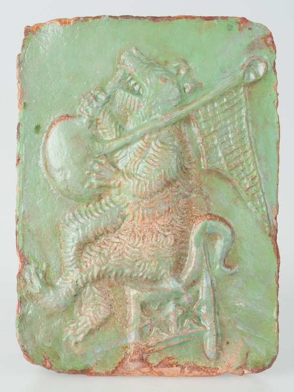 Kafel z wyobrażeniem niedźwiedzia grającego na dudach