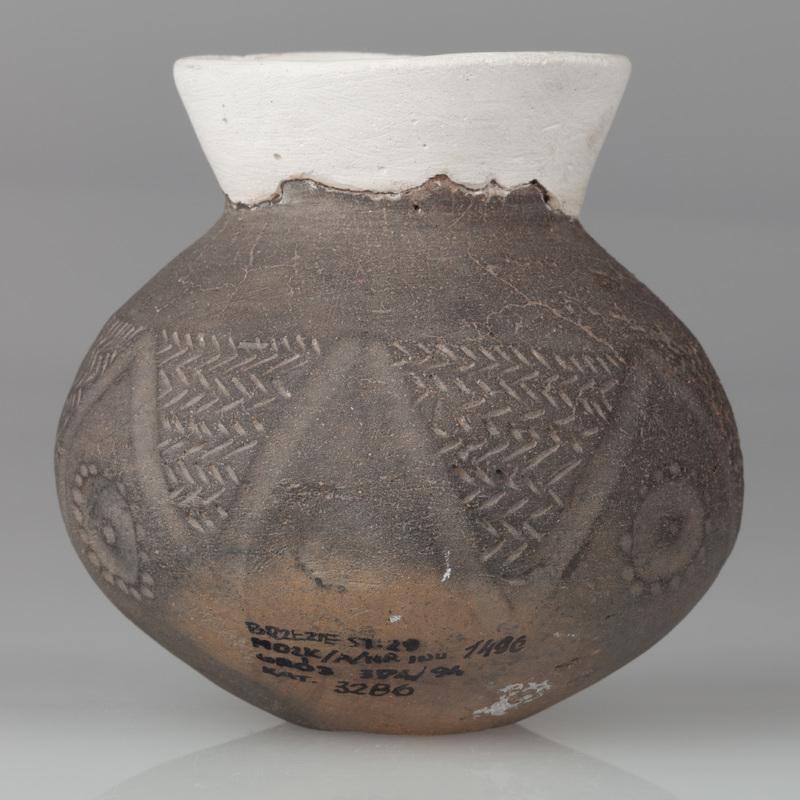 Czarka esowata o baniastym brzuścu, dnie wklęsłym, szyjce wychylonej na zewnątrz. Zdobiona ornamentem stempelkowym jodełkowym