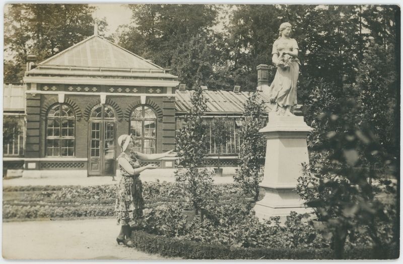 Posąg Flory w parku, w tle budynek oranżerii