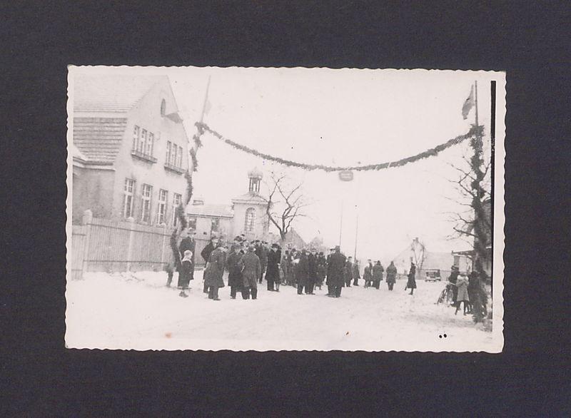 17 rocznica powstania wielkopolskiego w Zdziechowie. Na wysokości szkoły na dwóch słupach zwisająca girlanda oraz gromada mieszkańców oczekująca na uczestników rajdu.