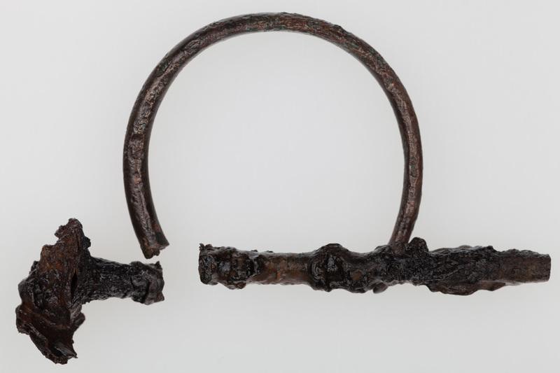 Fragment kółka brązowego o przekroju owalnym, z jednym końcem ułamanym, a drugim zwężającym się