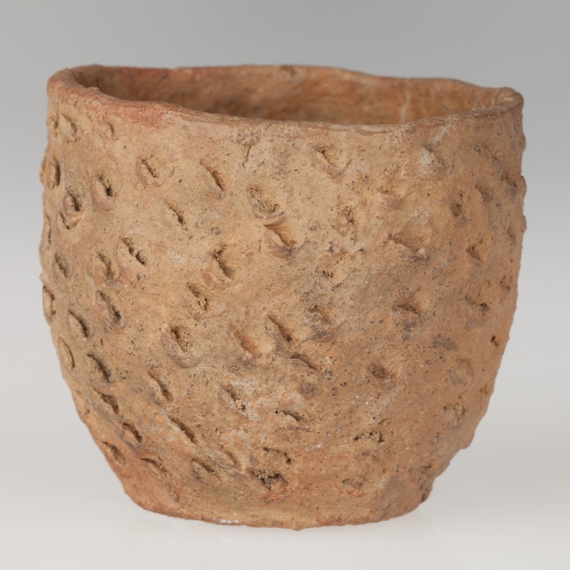 Miniaturowy garnek o beczułkowatym kształcie, pokryty ornamentem paznokciowym