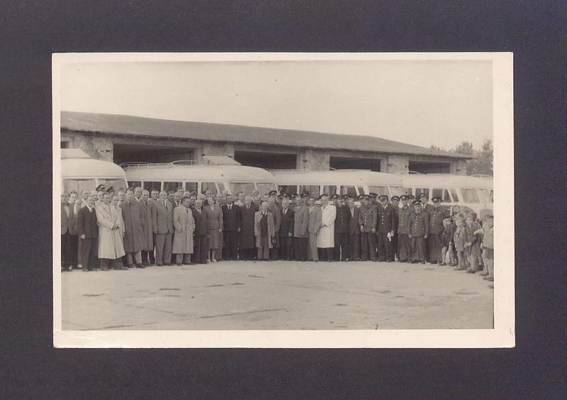 Uroczyste obchody MPGK w Gnieźnie. Uczestnicy uroczystości uruchomienia komunikacji miejskiej zgromadzeni przed zajezdnią.
