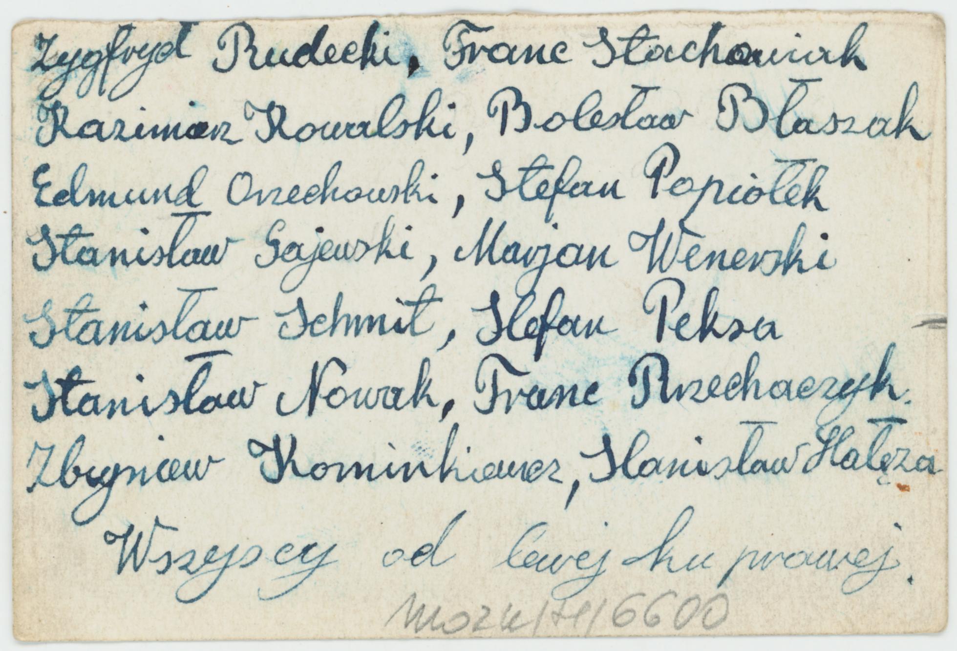 Fotografia grupy mężczyzn przed barakami