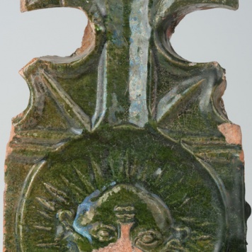 Kafel z wyobrażeniem słońca z ludzką twarzą i częścią w formie lilii 