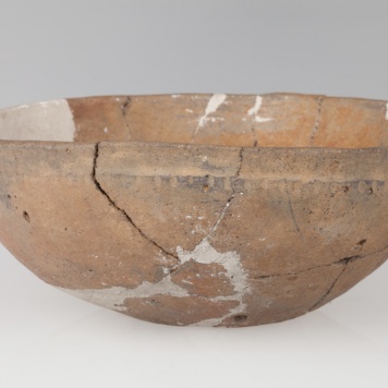 Misa półokrągła ze słabo zaznaczonym dnem, o gładkiej szyjce i szorstkim brzuścu. Ornamentowana dookolnymi pionowymi żłobkami.