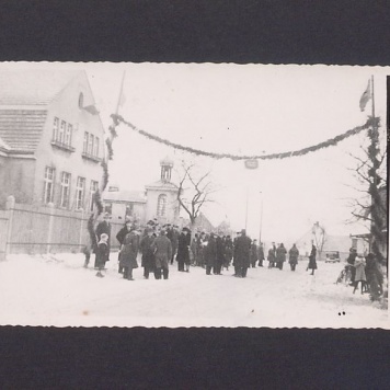 17 rocznica powstania wielkopolskiego w Zdziechowie. Na wysokości szkoły na dwóch słupach zwisająca girlanda oraz gromada mieszkańców oczekująca na uczestników rajdu.
