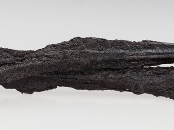 Żelazny grot włóczni o długim ostrzu, widocznym żeberku i okrągłej tulejce