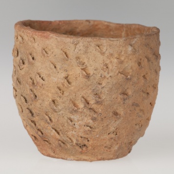 Miniaturowy garnek o beczułkowatym kształcie, pokryty ornamentem paznokciowym