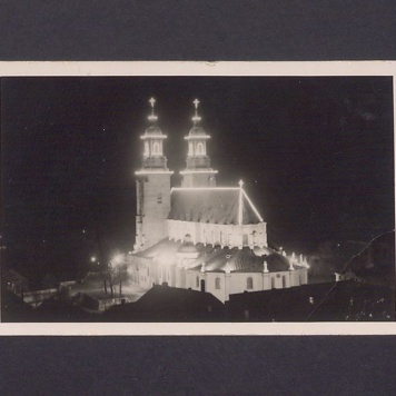 Widok z Rynku na odświętnie iluminowaną bazylikę.