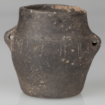 Garnek beczułkowaty, zaopatrzony w dwa kolankowate uszka