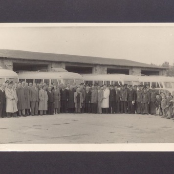 Uroczyste obchody MPGK w Gnieźnie. Uczestnicy uroczystości uruchomienia komunikacji miejskiej zgromadzeni przed zajezdnią.
