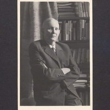 Prof. Bolesław Kasprowicz (junior) na tle regału z książkami.